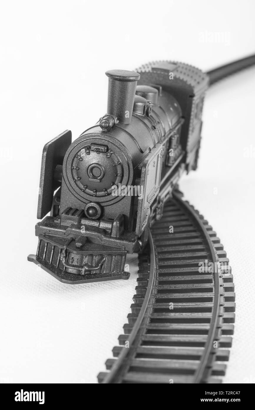 Black painted toy steam engine model. For off track, financial crash, knocked off course, train accident, Oops, derailment, SVB bank collapse metaphor Stock Photo