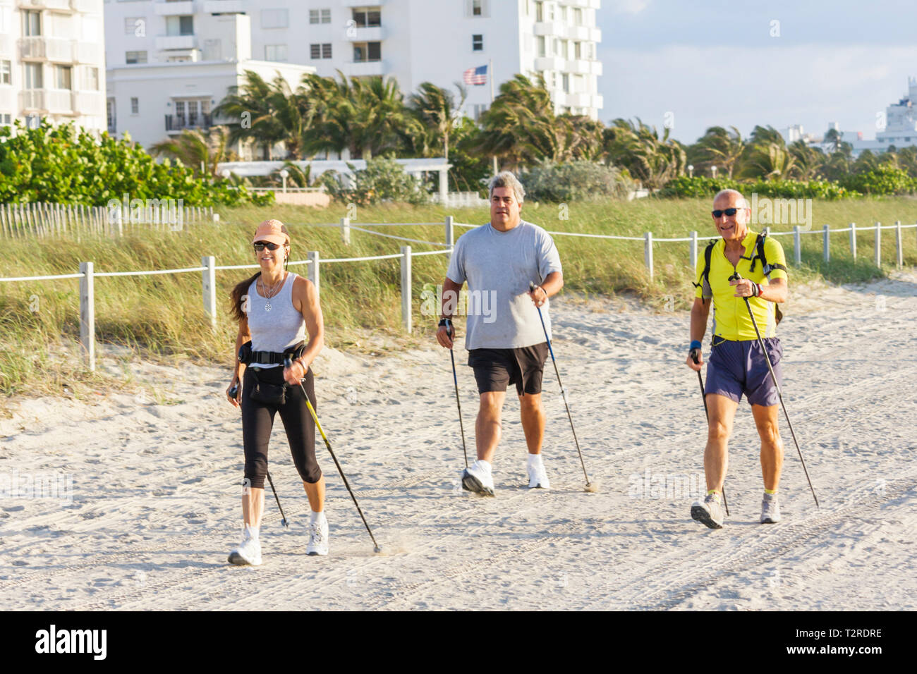 Miami Beach Florida,Nordic walking,pole,ski,fitness,sand,woman female women,man men male,exercise,overweight obese obesity fat heavy plump rotund stou Stock Photo