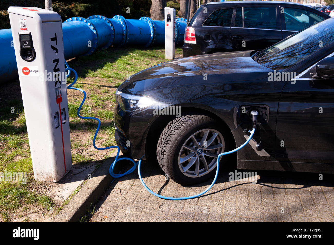 a BMW 530e at a charging station of the Mobilstation on the Charles-de-Gaulle square in the district Deutz, Cologne, Germany. With a direct connection Stock Photo