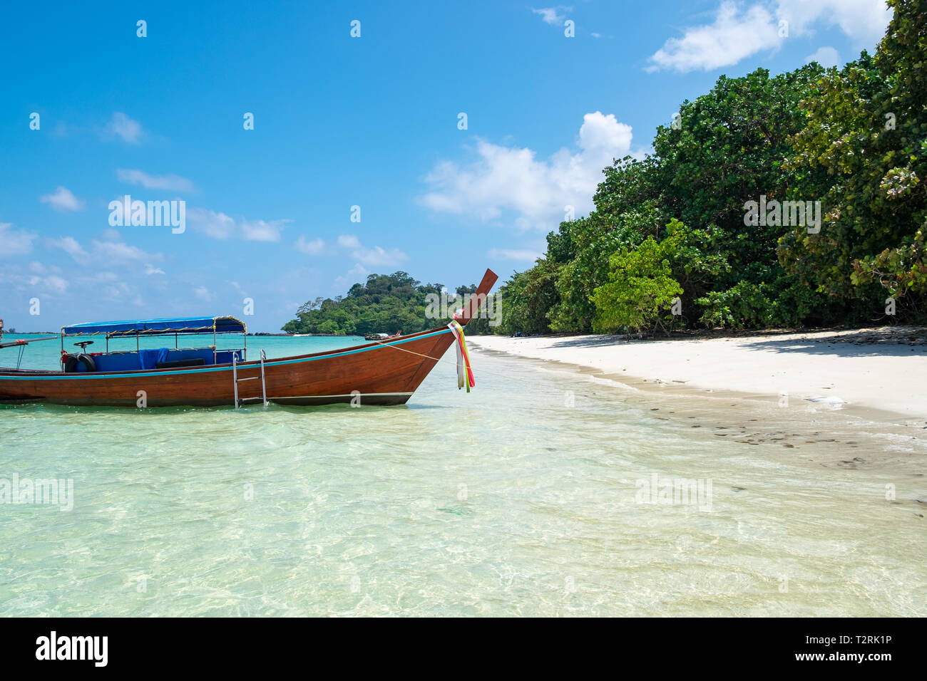 Long tail wooden boat anchor with csytal sea white sand at lipe island,andaman,thailand Stock Photo