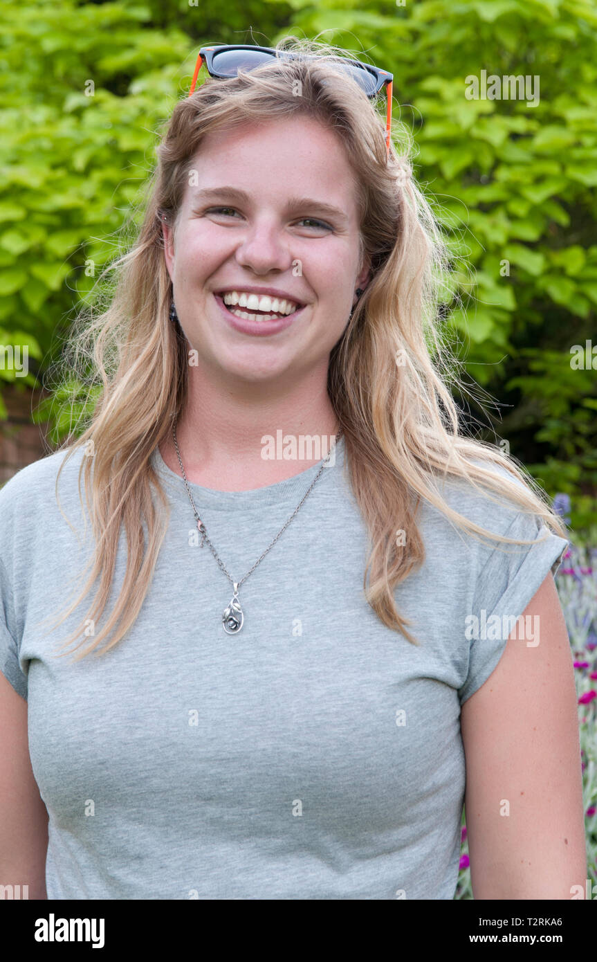 Pretty young woman smiling at the camera Stock Photo - Alamy
