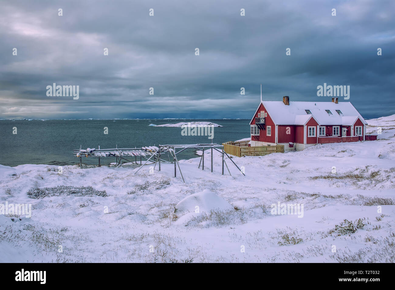 Single wooden house in the snow-covered disco bay of Ilulissat in Greenland Stock Photo