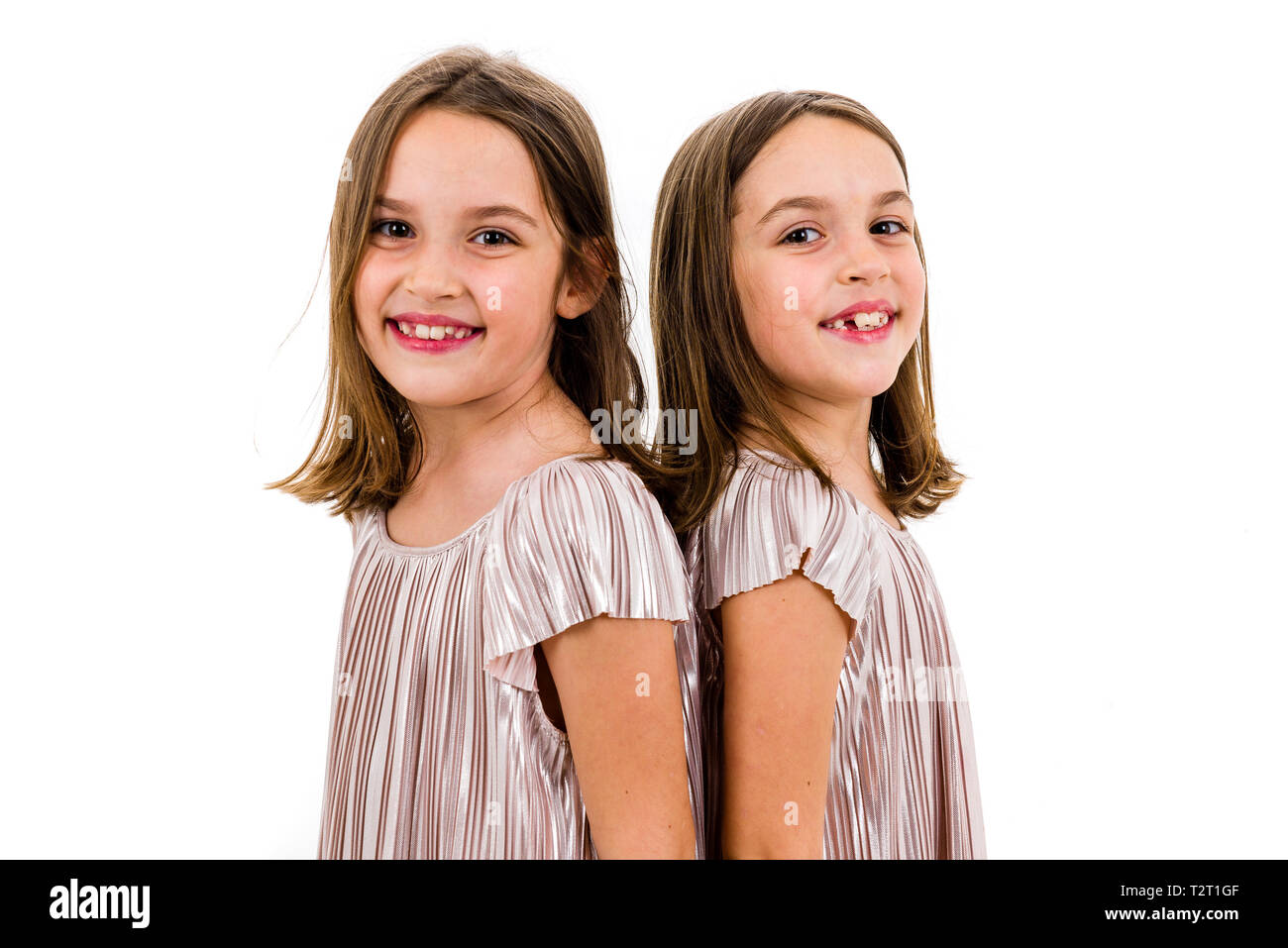 Identical twin girls are turned facing back to back Concept of family