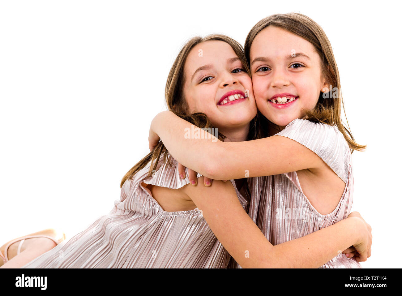 Identical Twin Girls Sisters Are Posing For The Camera Happy Twin Sisters In Dresses Looking At