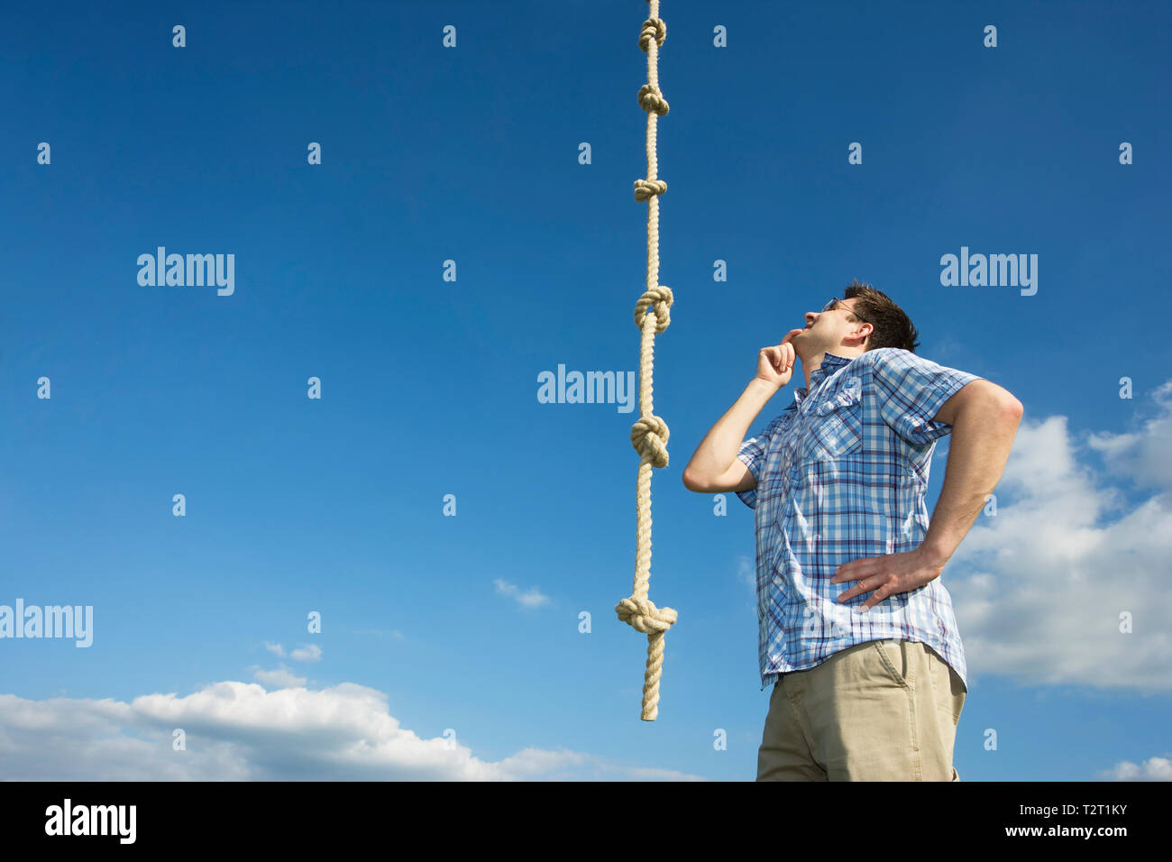 A caucasian man looking at a knotted rope Stock Photo