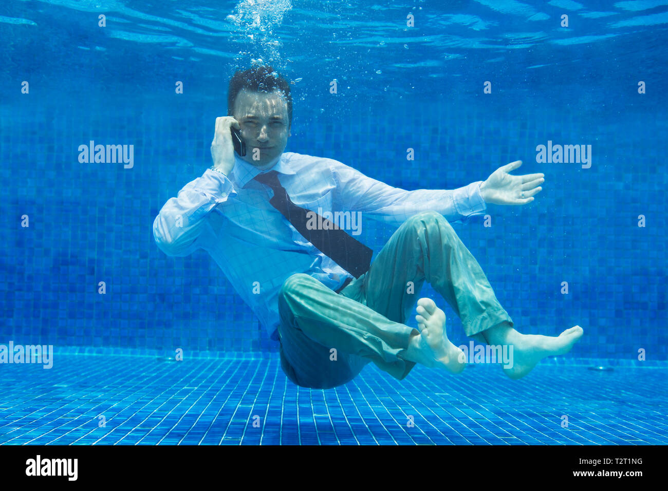 Caucasian businessman talking on a mobile phone underwater Stock Photo