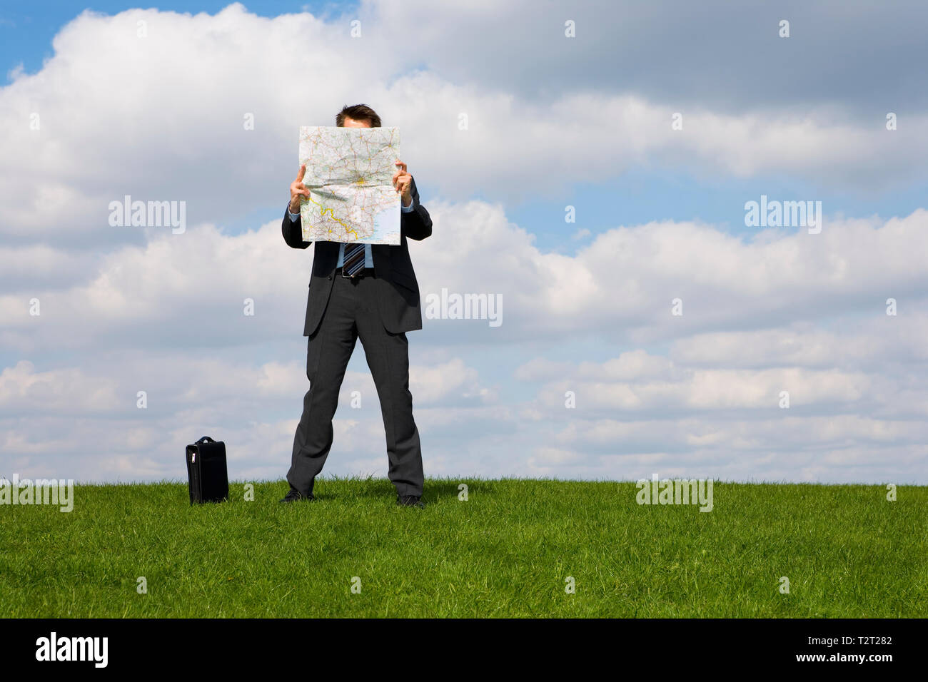 Caucasian businessman reading a map in a field Stock Photo