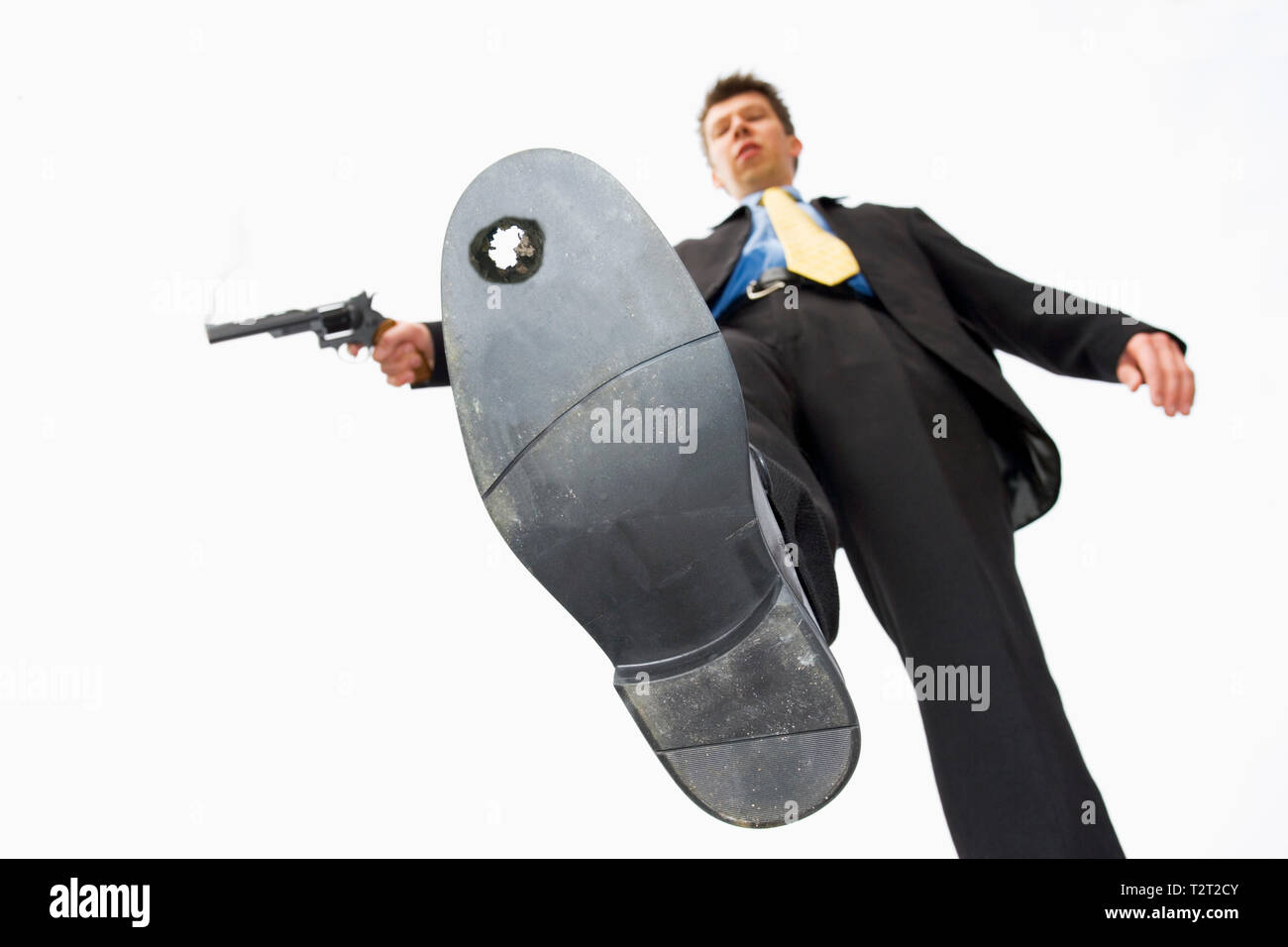 Businessman shooting himself in the foot Stock Photo