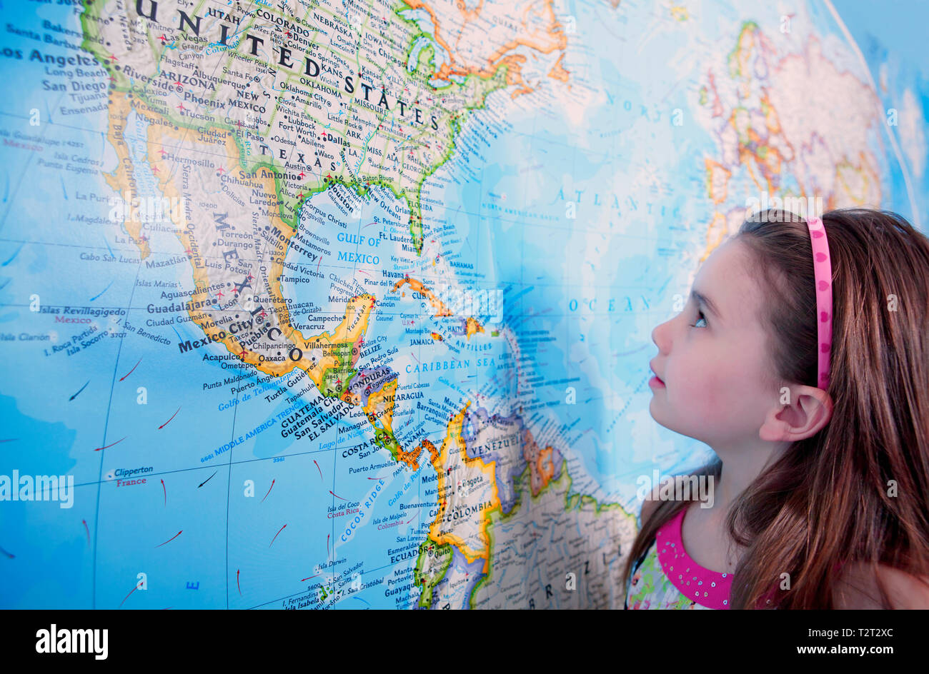 A young caucasian girl looking at the USA on a large map Stock Photo