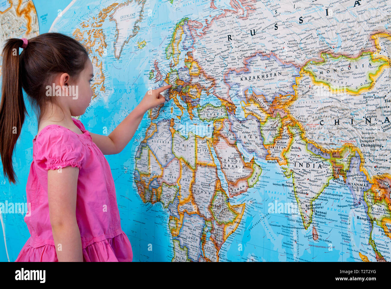 Pre teen caucasian girl pointing to Europe on a map Stock Photo