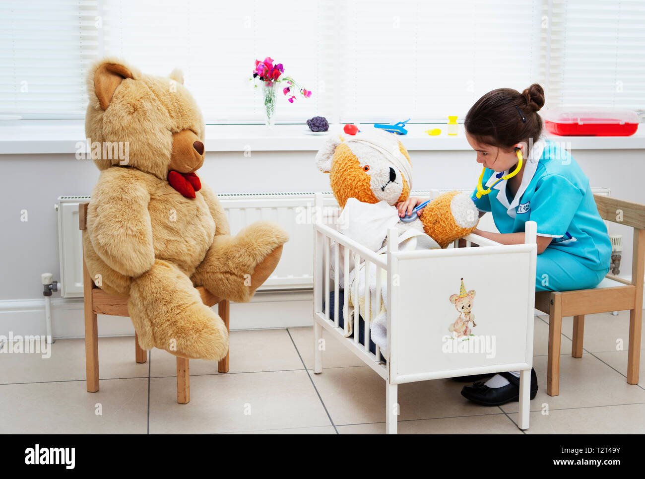 Caucasian girl pretending to be a nurse to her teddy bear Stock Photo