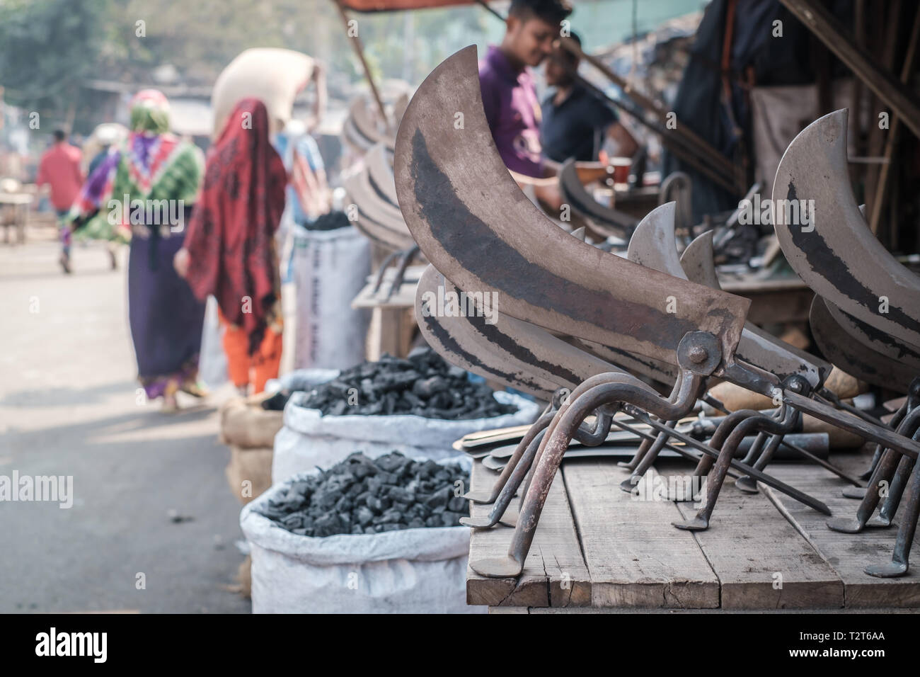 Metal tools on display in the workshop on the local market in Dhaka, Bangladesh. 2 unrecognizable muslim women in the background. Stock Photo
