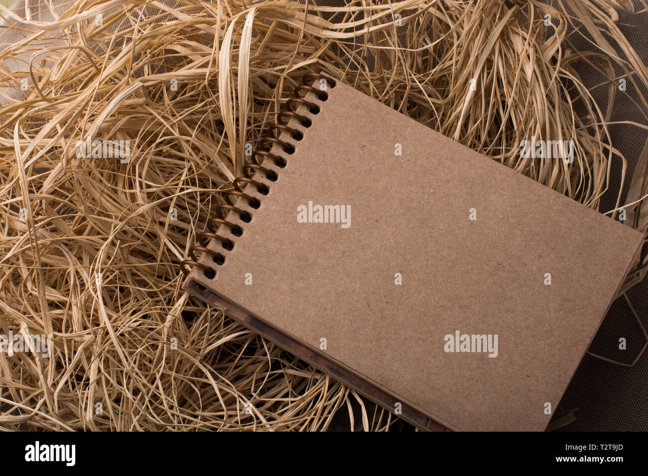 Spiral notebook placed on a straw background Stock Photo - Alamy