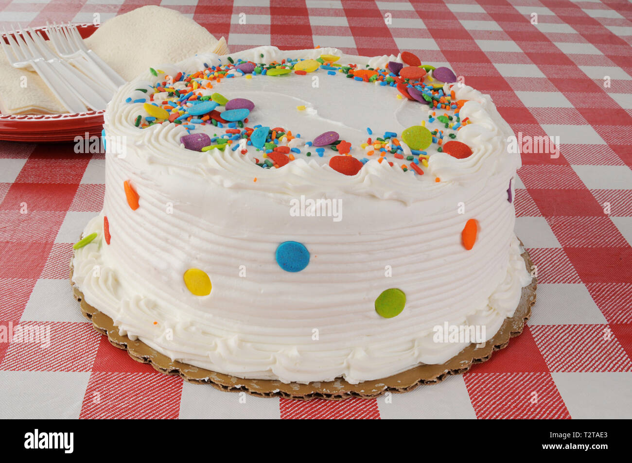 A white cake with candy sprinkles on top Stock Photo - Alamy