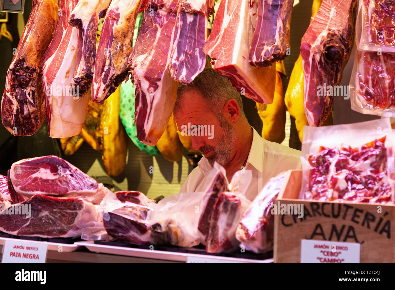 Butcher and meats in a meat stall, Mercado Central de Atarazanas (Malaga Indoor market ), Malaga, Andalusia Spain Stock Photo