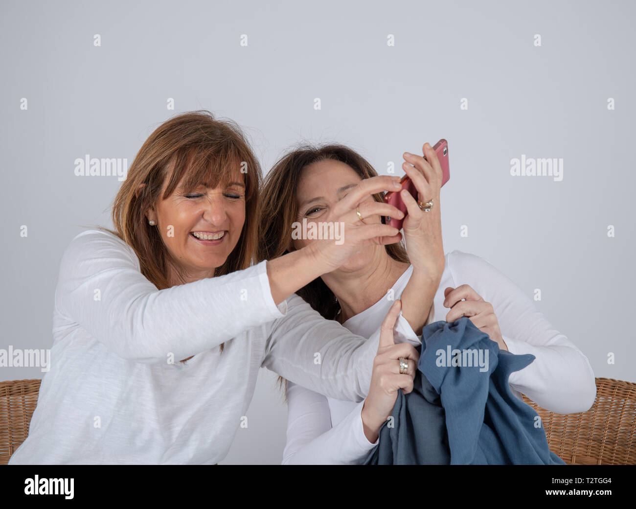 Two 50-year-old friends take a photo with their mobile phone Stock Photo