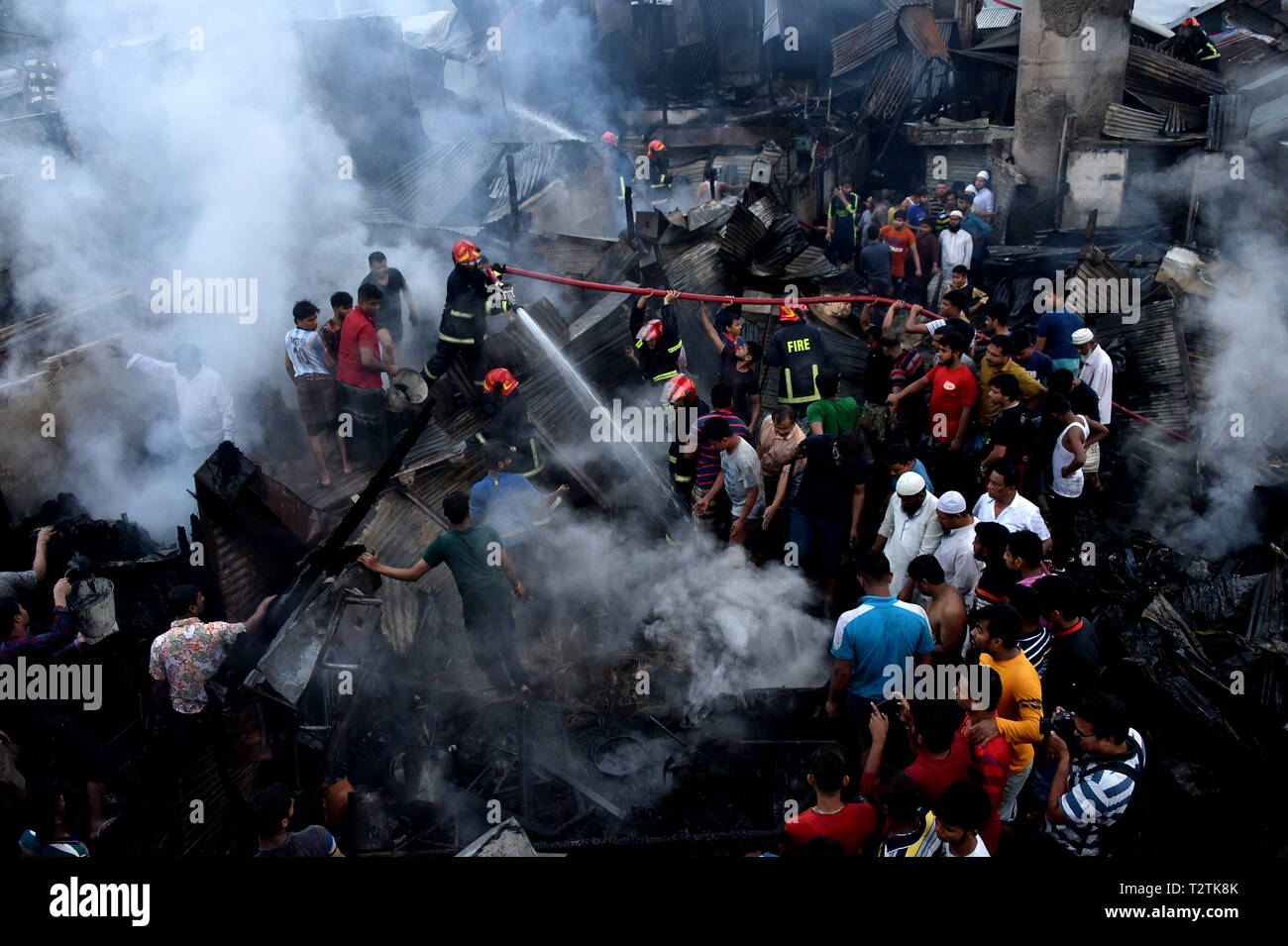 Dhaka, Bangladesh. 4th Apr, 2019. Firefighters spray water to douse flame after a fire broke out at a kitchen market in Dhaka, Bangladesh, April 4, 2019. An early morning fire gutted dozens of shops in a kitchen market in Bangladesh capital Dhaka on Thursday, Kazi Nazmuzzaman, deputy assistant director of Fire Service and Civil Defense, told Xinhua. Credit: Stringer/Xinhua/Alamy Live News Stock Photo