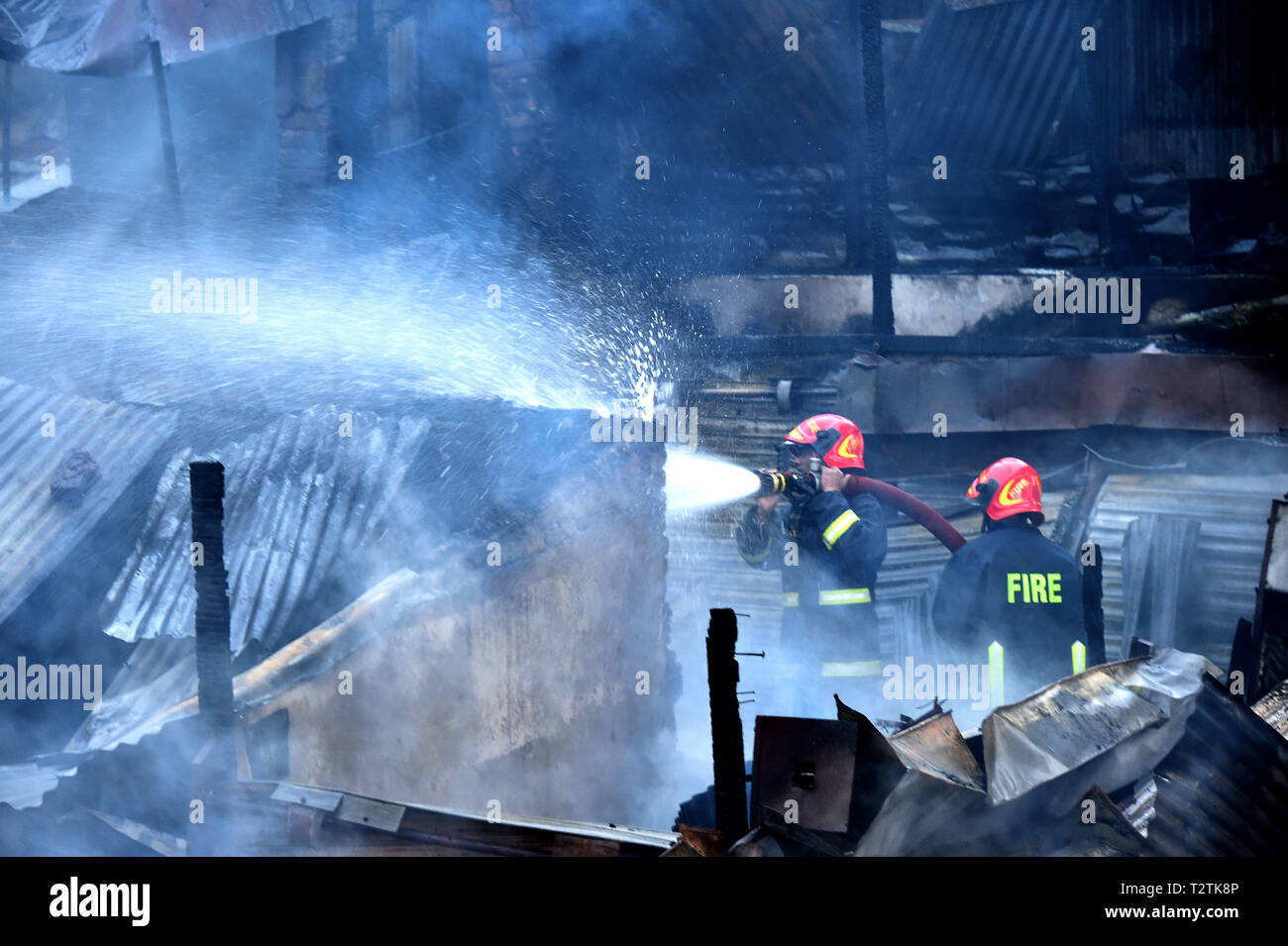 Dhaka, Bangladesh. 4th Apr, 2019. Firefighters spray water to douse flame after a fire broke out at a kitchen market in Dhaka, Bangladesh, April 4, 2019. An early morning fire gutted dozens of shops in a kitchen market in Bangladesh capital Dhaka on Thursday, Kazi Nazmuzzaman, deputy assistant director of Fire Service and Civil Defense, told Xinhua. Credit: Stringer/Xinhua/Alamy Live News Stock Photo