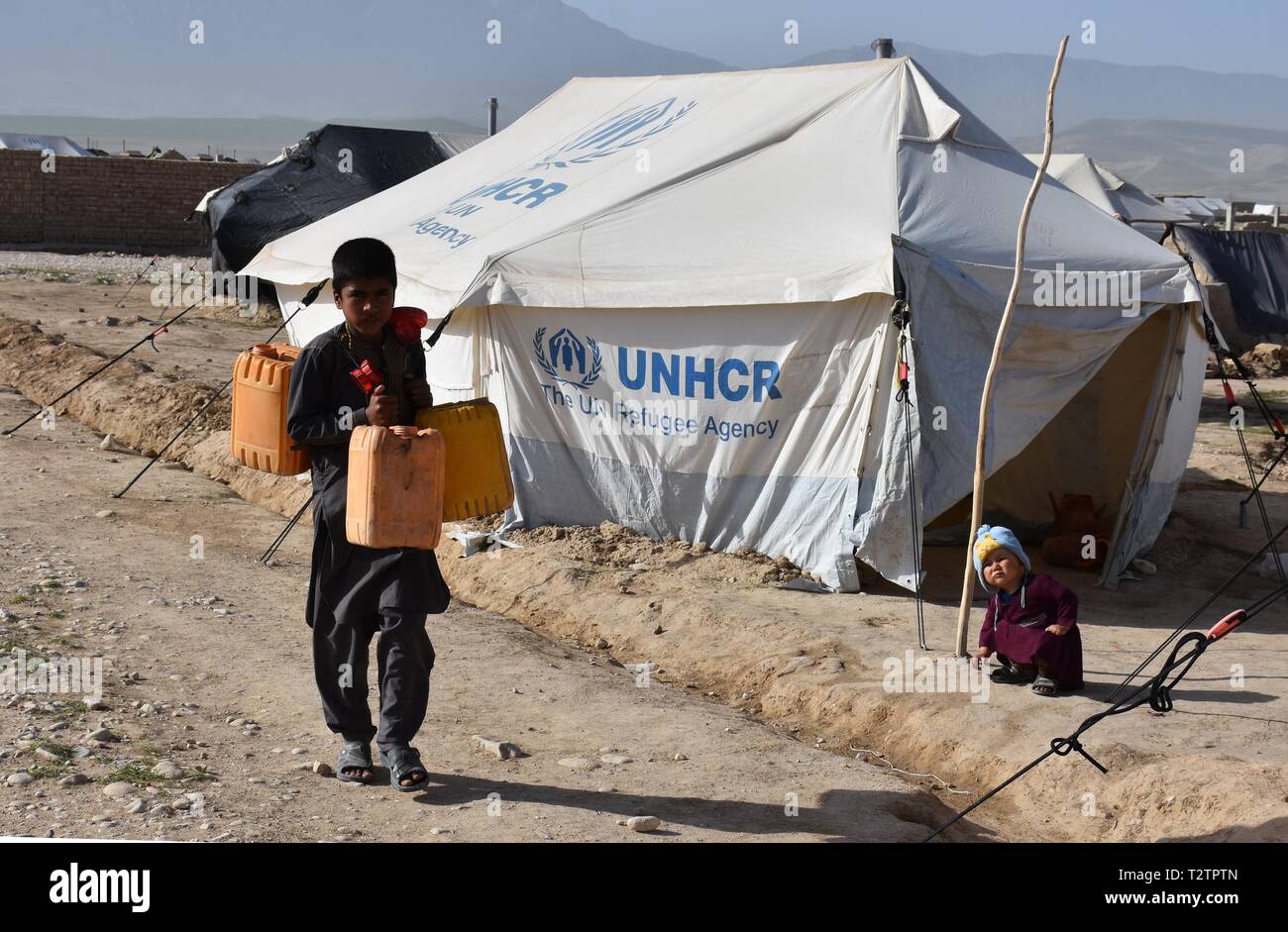 Balkh, Afghanistan. 4th Apr, 2019. A child carries barrels of water at a makeshift camp in Mazar-i-Sharif, capital of Balkh province, Afghanistan, April 4, 2019. More than 42,000 Afghans have been displaced following flooding in the country within the past one month and most needs supplies, the UN Office for the Coordination of Humanitarian Affairs (OCHA) reported on Wednesday. Credit: Kawa Basharat/Xinhua/Alamy Live News Stock Photo