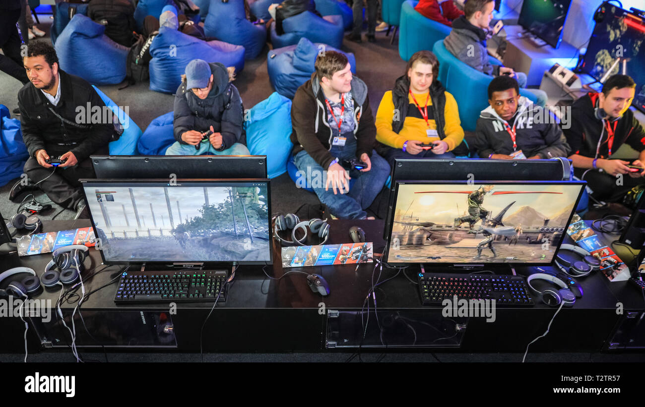 Tobacco Dock, London, UK, 4th April 2019. People chill out on beanbags  whilst playing games. Gamers, developers and console players of all ages  once again meet at EGX Rezzed in London's Tobacco