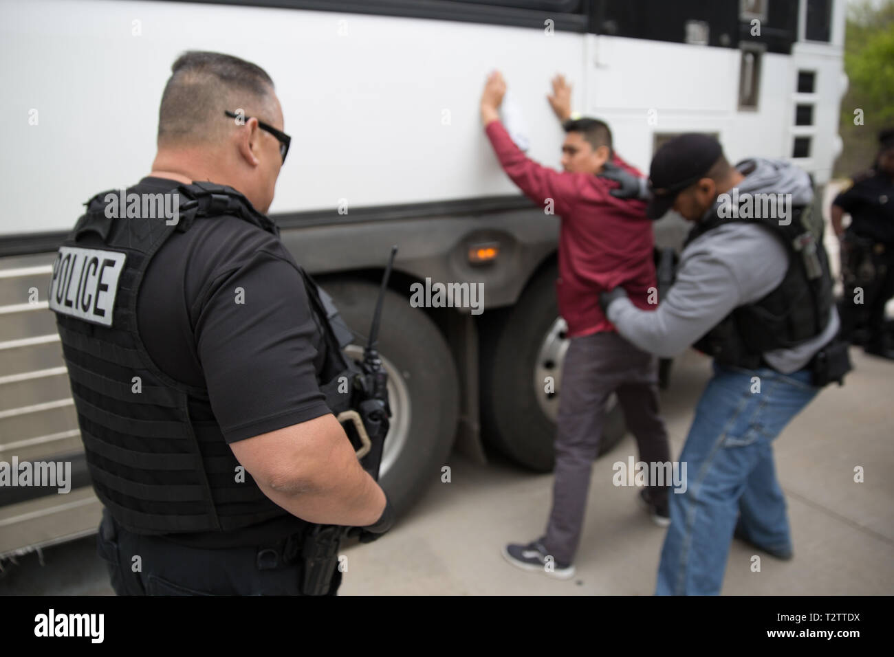 U.S. Immigration and Customs Enforcement agents search a suspected undocumented immigrant during a raid at CVE Technology Group April 3, 2019 in Allen, Texas. ICE agents arrested 280 employees of the cellphone repair company in the largest worksite operation in more than a decade. Stock Photo