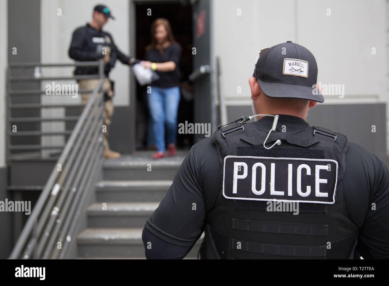 U.S. Immigration and Customs Enforcement agents escort a suspected undocumented immigrant to detention during a raid at CVE Technology Group April 3, 2019 in Allen, Texas. ICE agents arrested 280 employees of the cellphone repair company in the largest worksite operation in more than a decade. Stock Photo