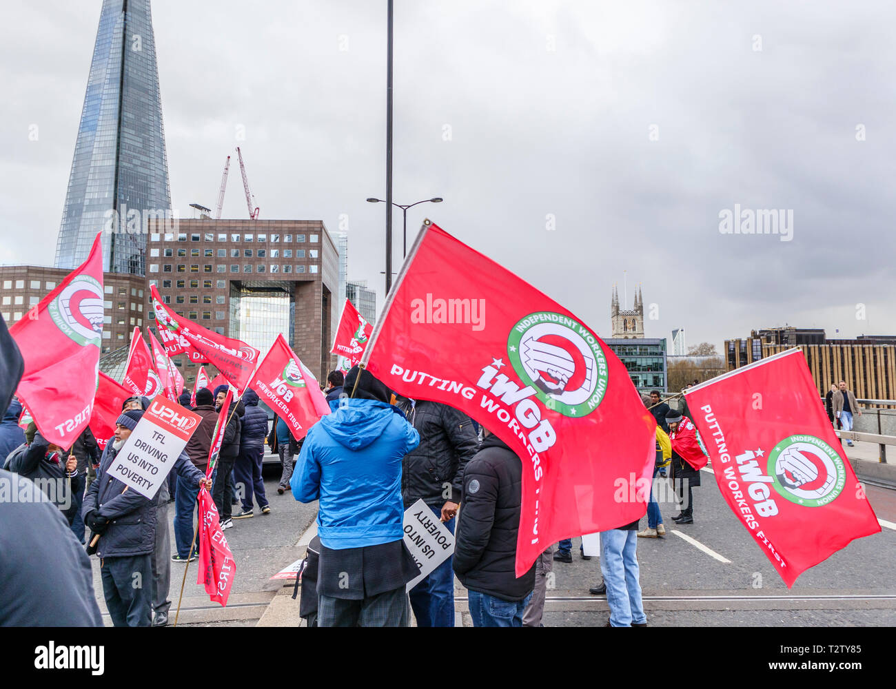 London, UK, 04th April 2019. Minicab drivers block the road on London Bridge protesting against the congestion change on private hire minicabs.  The demonstrators hold and wave flags and placards of UPHD (United Prive Hire Drivers) and IWGB (Independent Workers Union of Great Britain). Credit: Graham Prentice/Alamy Live News Stock Photo