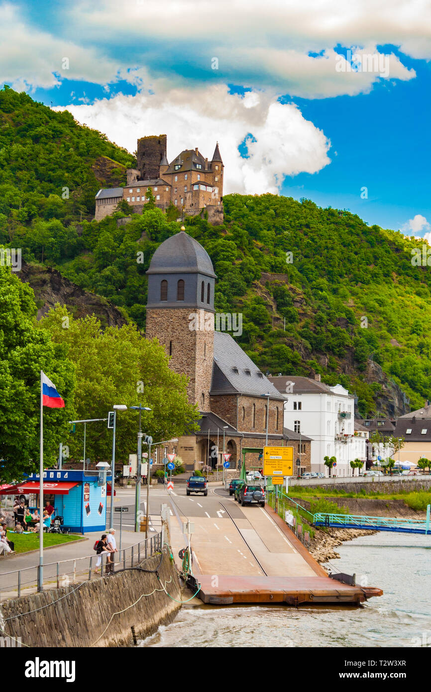 Nice view of the town St. Goarshausen with its ferry landing connected to the main road at the catholic St. Johannes Church on a sunny day with blue... Stock Photo