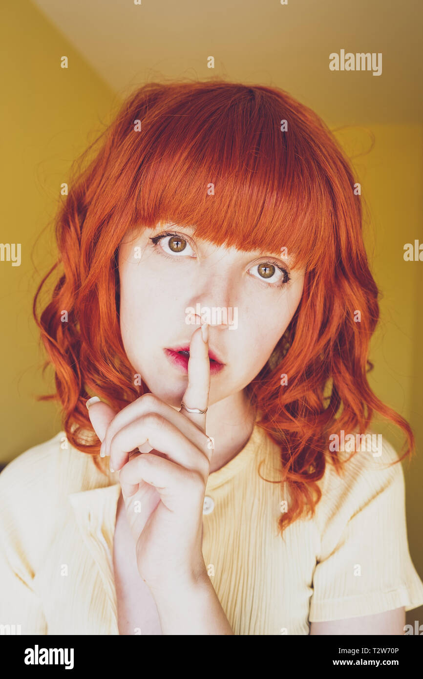 Young redhead woman doing a silent gesture Stock Photo - Alamy