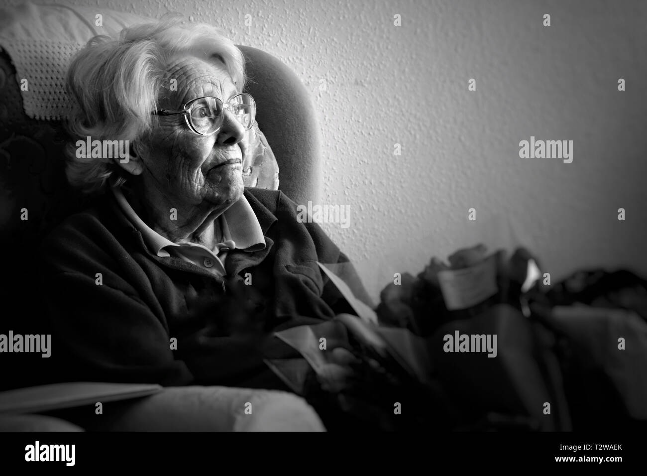 Black and white image of an elderly woman feeling sad and lonely - John Gollop Stock Photo