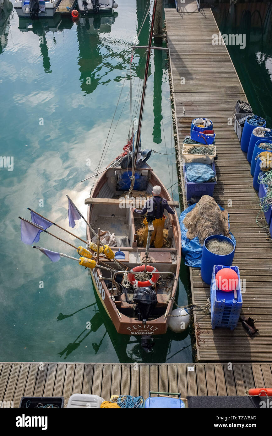 Brighton Marina Views UK Fisherman working on his nets in small