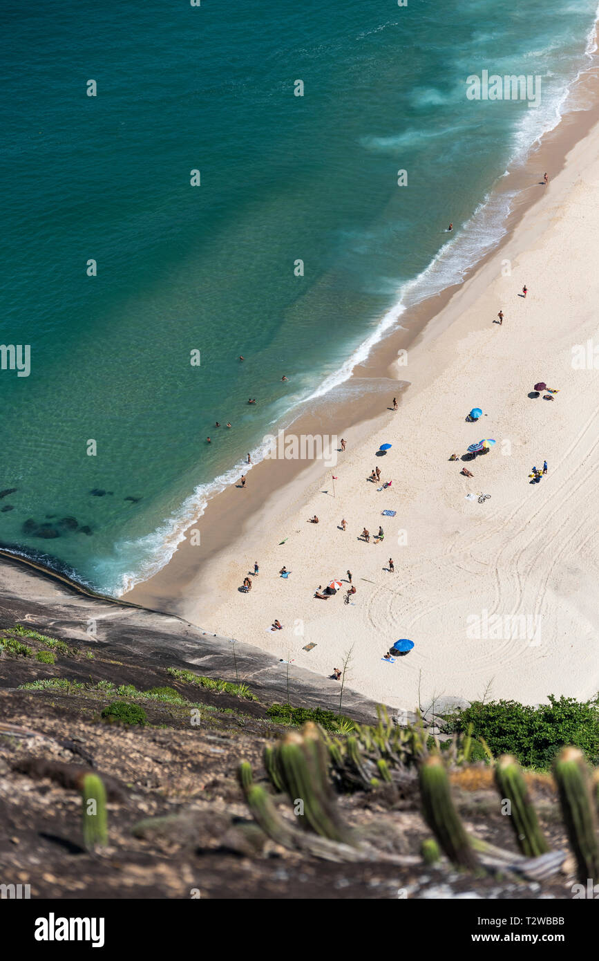 Photography of a beach of crystalline waters, white sand and tents. Stock Photo
