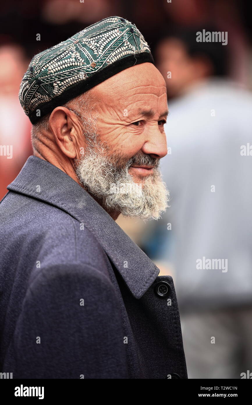 Bearded Uyghur man wearing doppa-skullcap at the city's bazaar. Hotan-Xinjiang-China-0077 Stock Photo