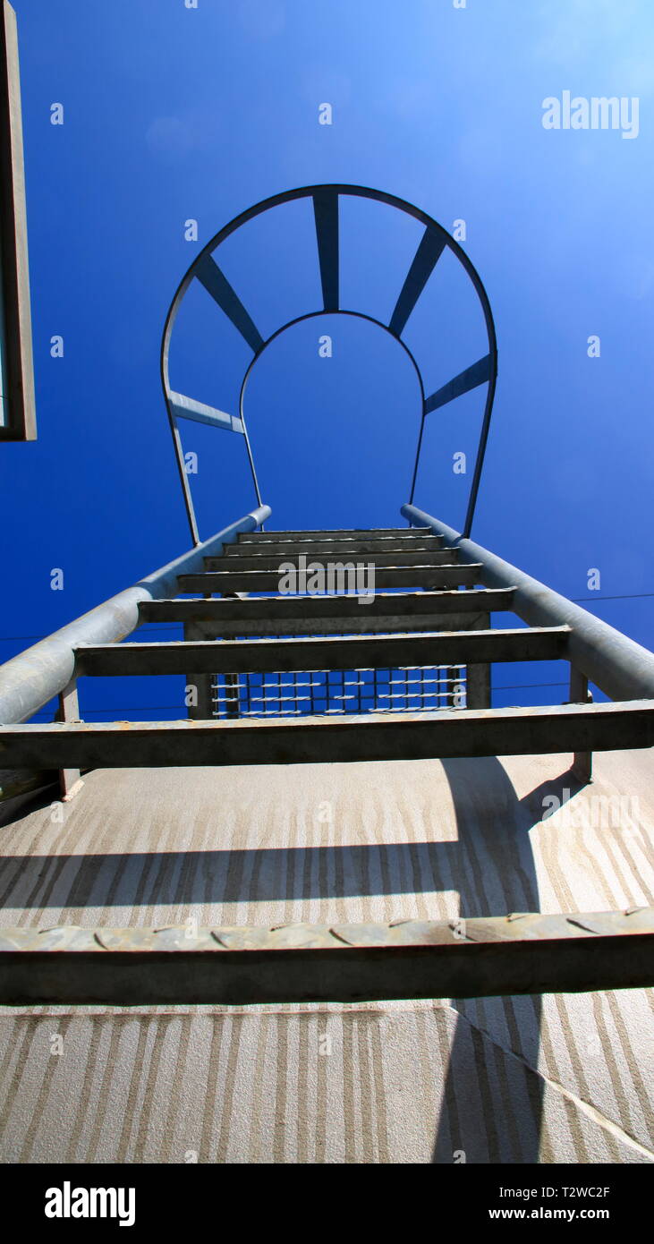 View from below of a ladder with safety bar. The look Symbolizes the ascent with certainty Stock