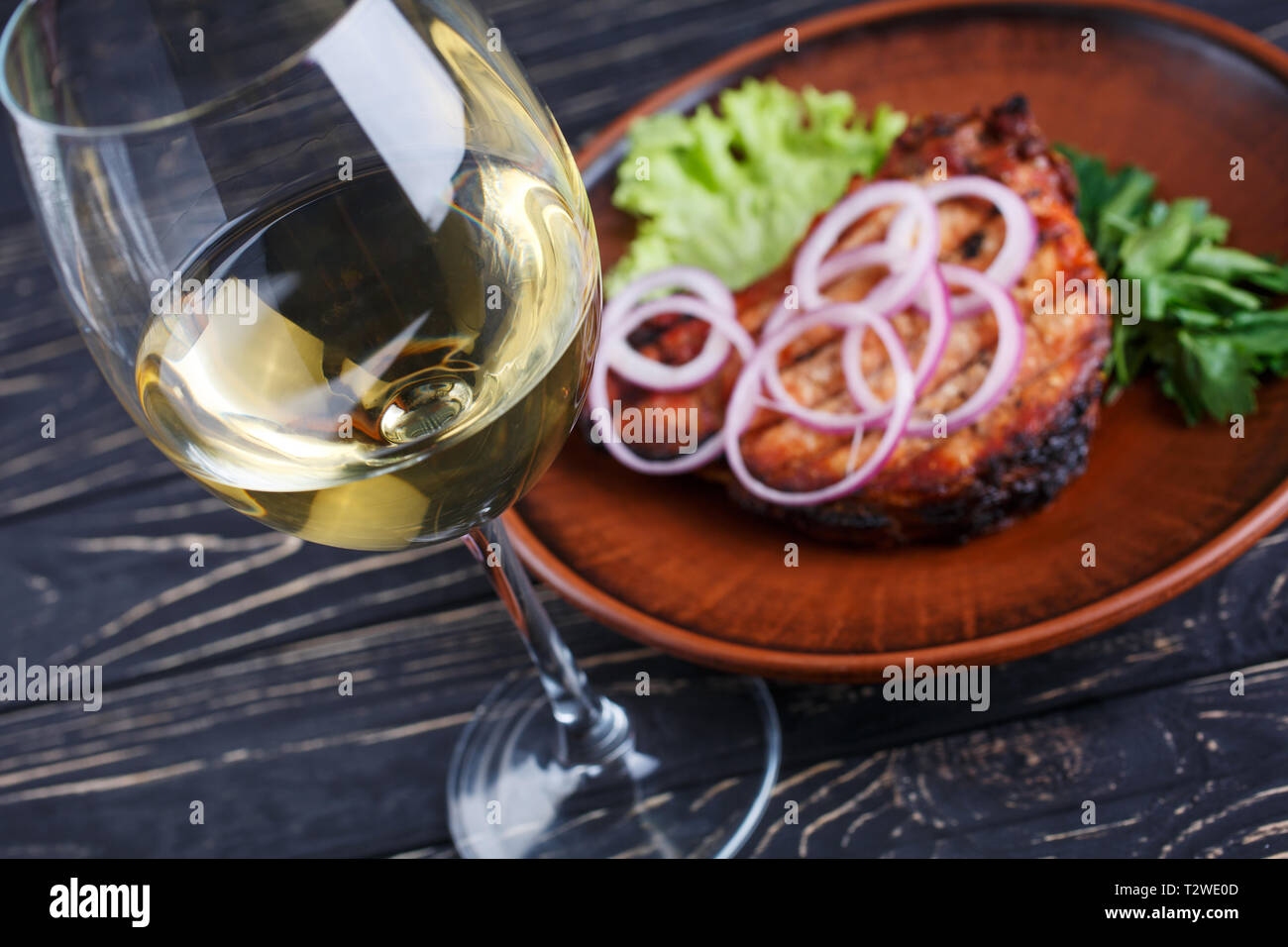 A glass of white semidry wine with steak in the restaurant Stock Photo