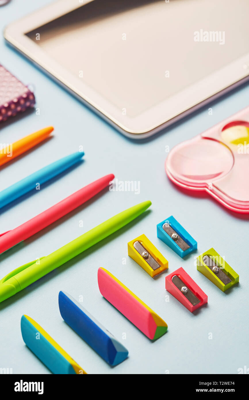 Bright gum, sharpeners and pens on a blue table. Composition lined with school supplies on a blue background Stock Photo