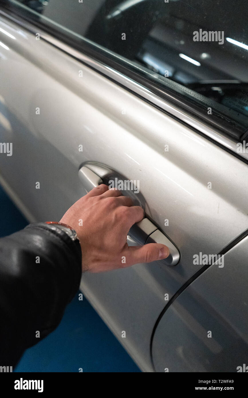 Closeup A Men S Hand On The Latch Of A Car Door Opening It Up