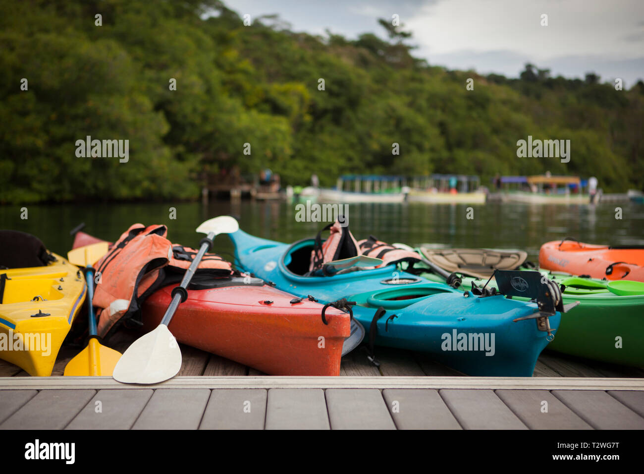 A row of colorful ocean kayaks sitting in a row on a dock. Panama, Bocas Del Toro. Stock Photo
