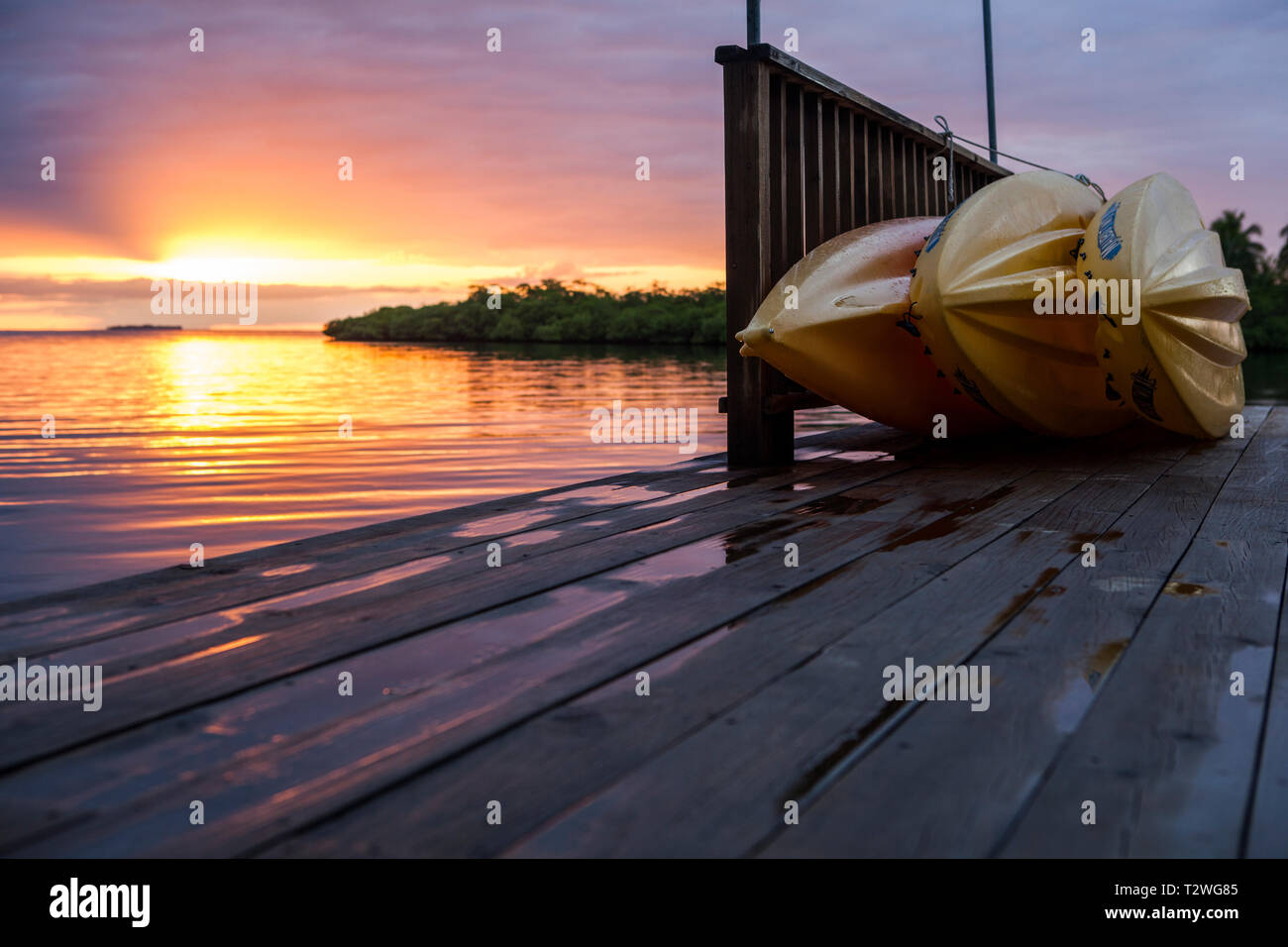 Kayaks ready on the dock at sunrise Stock Photo