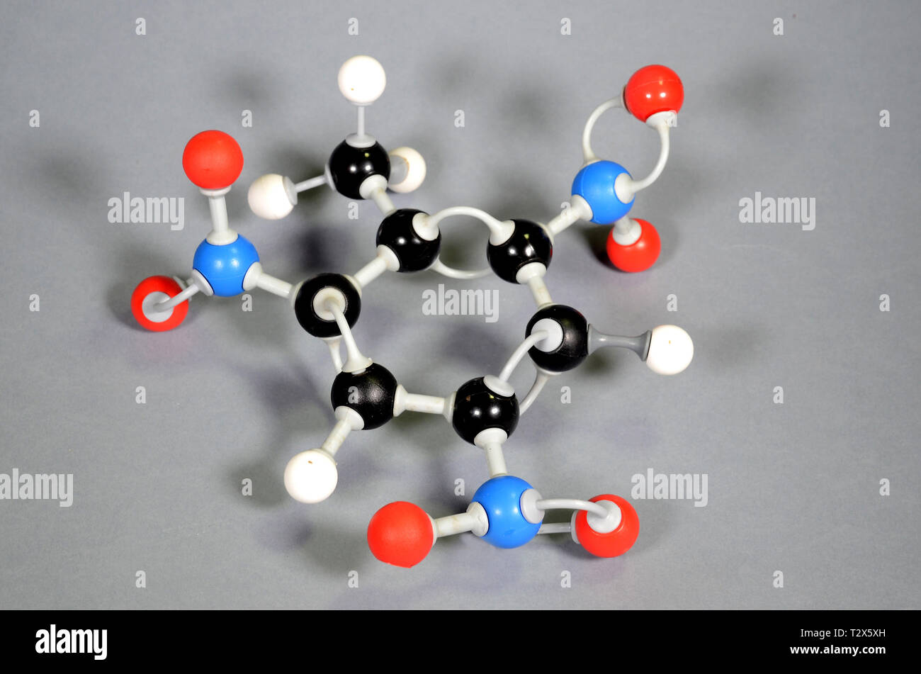 Molecule model of TNT (Trinitrotoulene). Red is oxygen, black is carbon, blue is nirogen and white is hydrogen. Stock Photo