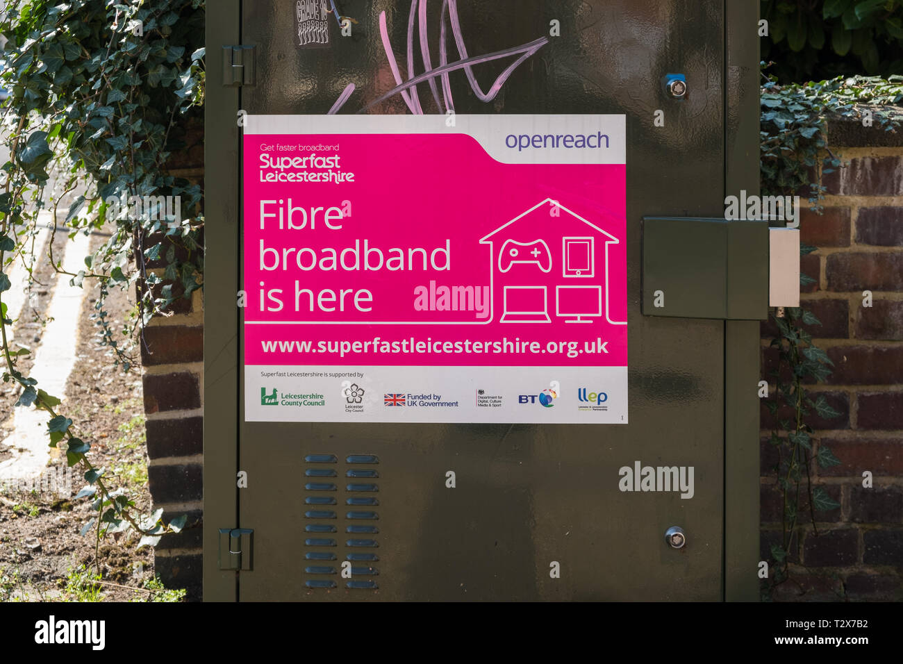 Bright pink sign on BT Openreach broadband unit announcing super fast fibre broadband is here Stock Photo