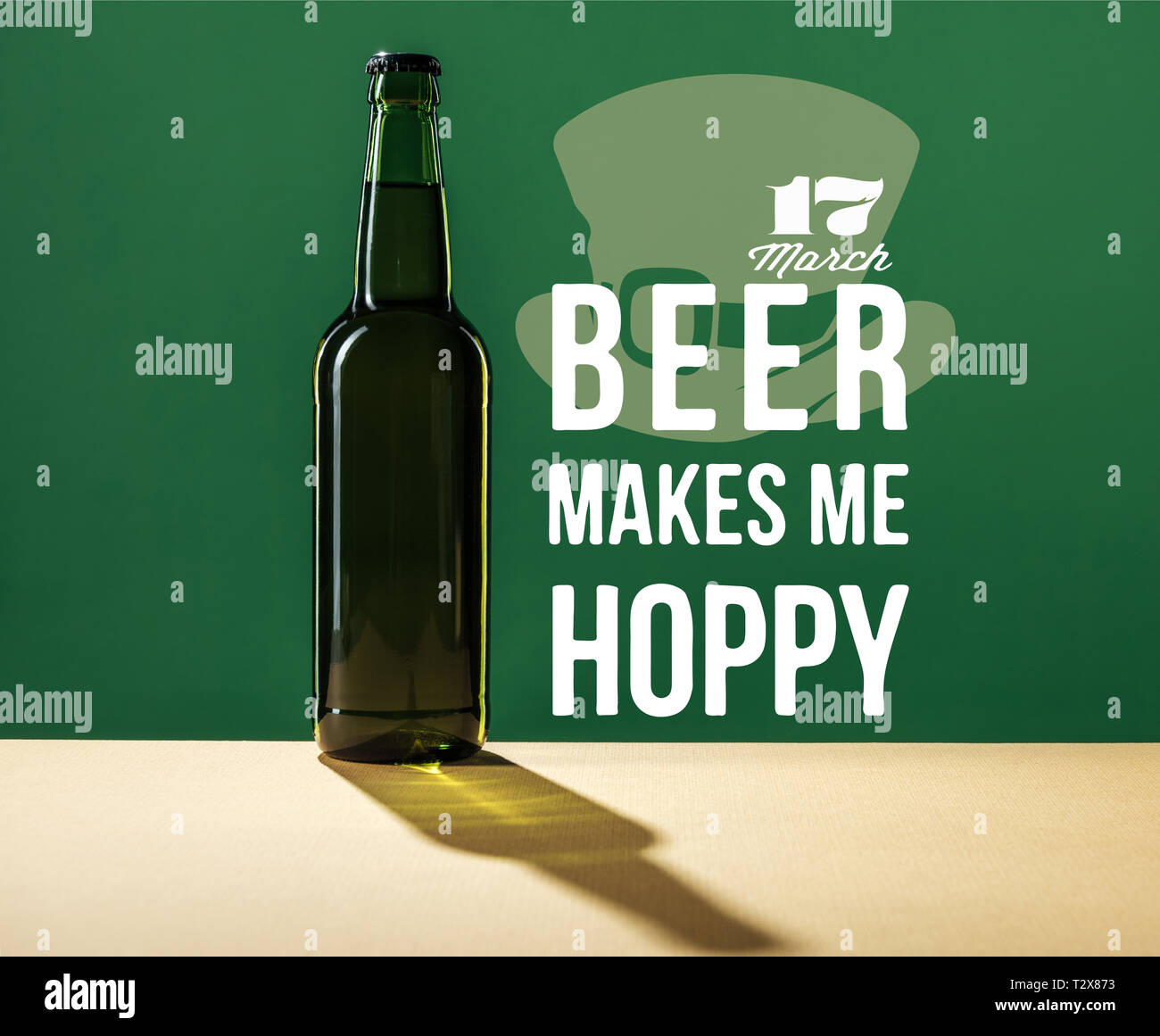 glass beer bottle near beer makes me hoppy lettering on green background Stock Photo