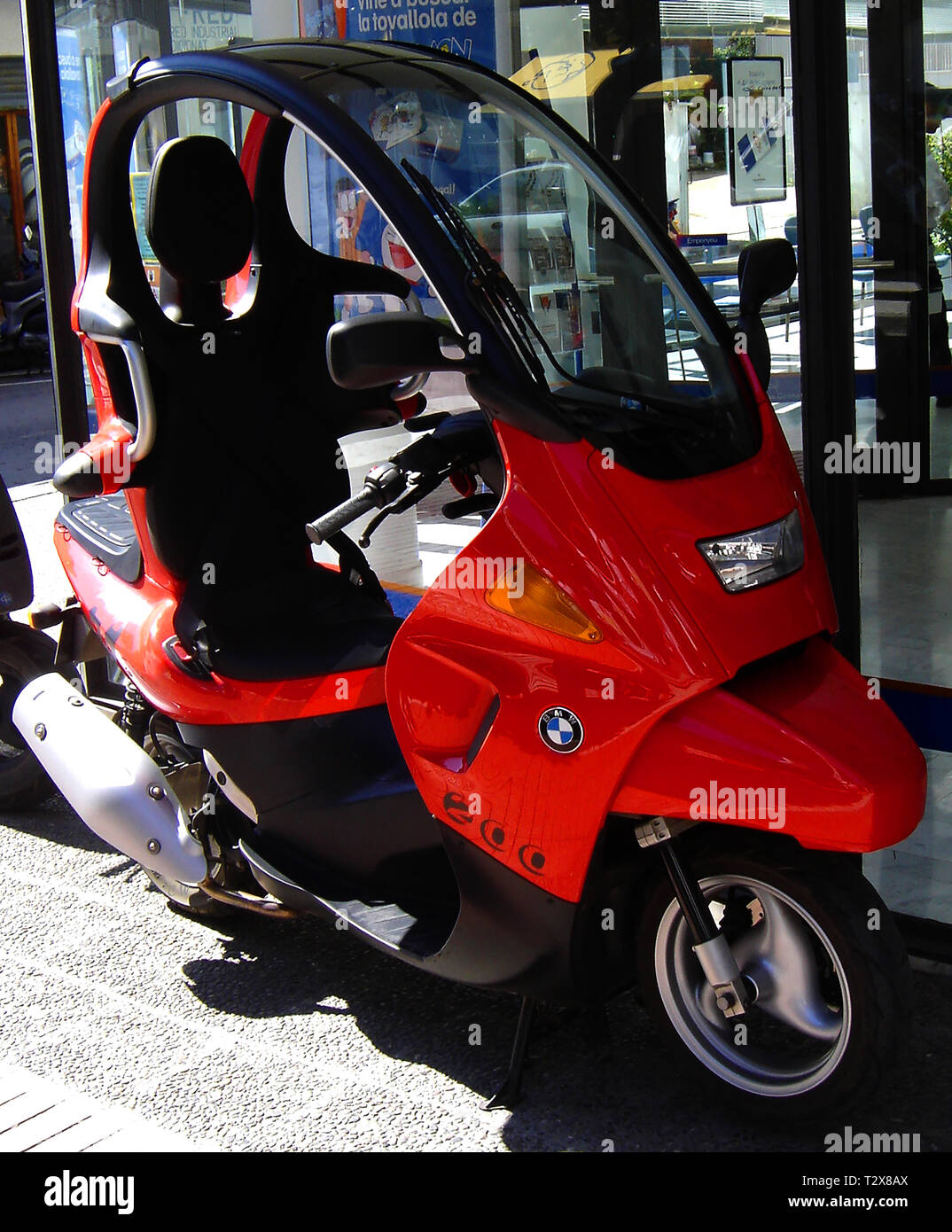 A vintage (2005) photograph of an enclosed  red  BMW 200 Motor Scooter with weather protector,taken  at Tossa de Mar, Spain - Manufactured for BMW by Gruppo Bertone Stock Photo