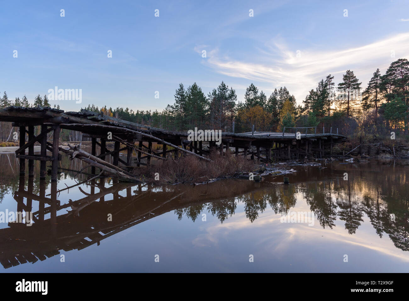 Old wooden bridge over the river in the forest Stock Photo