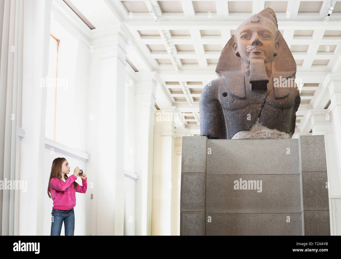 Young girl photographing a statue in a museum Stock Photo