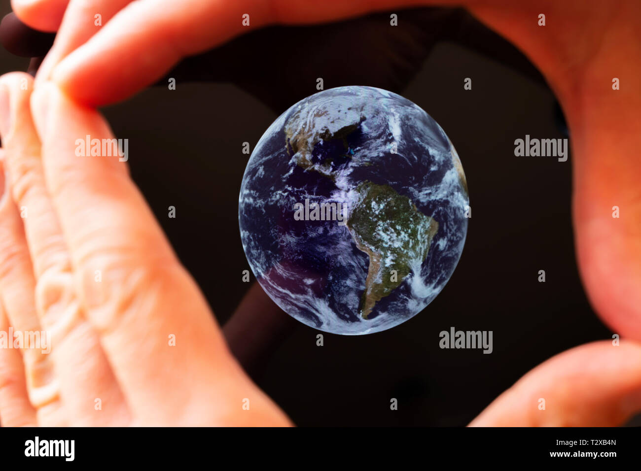 A caucasian man framing the earth in his hands Stock Photo