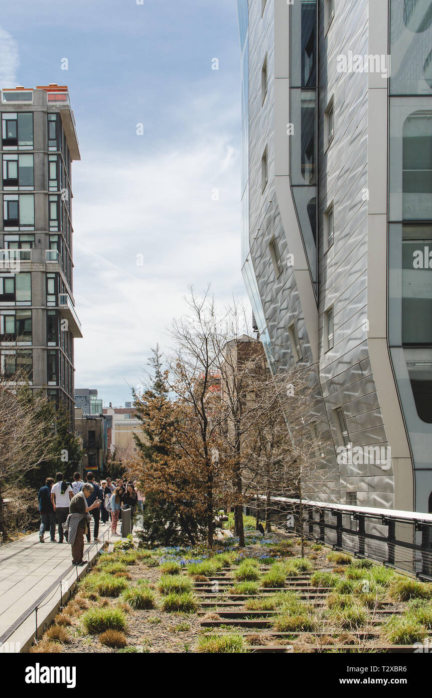 New York - April 9th 2017: People walking the High Line and taking photos of HL23 building Stock Photo