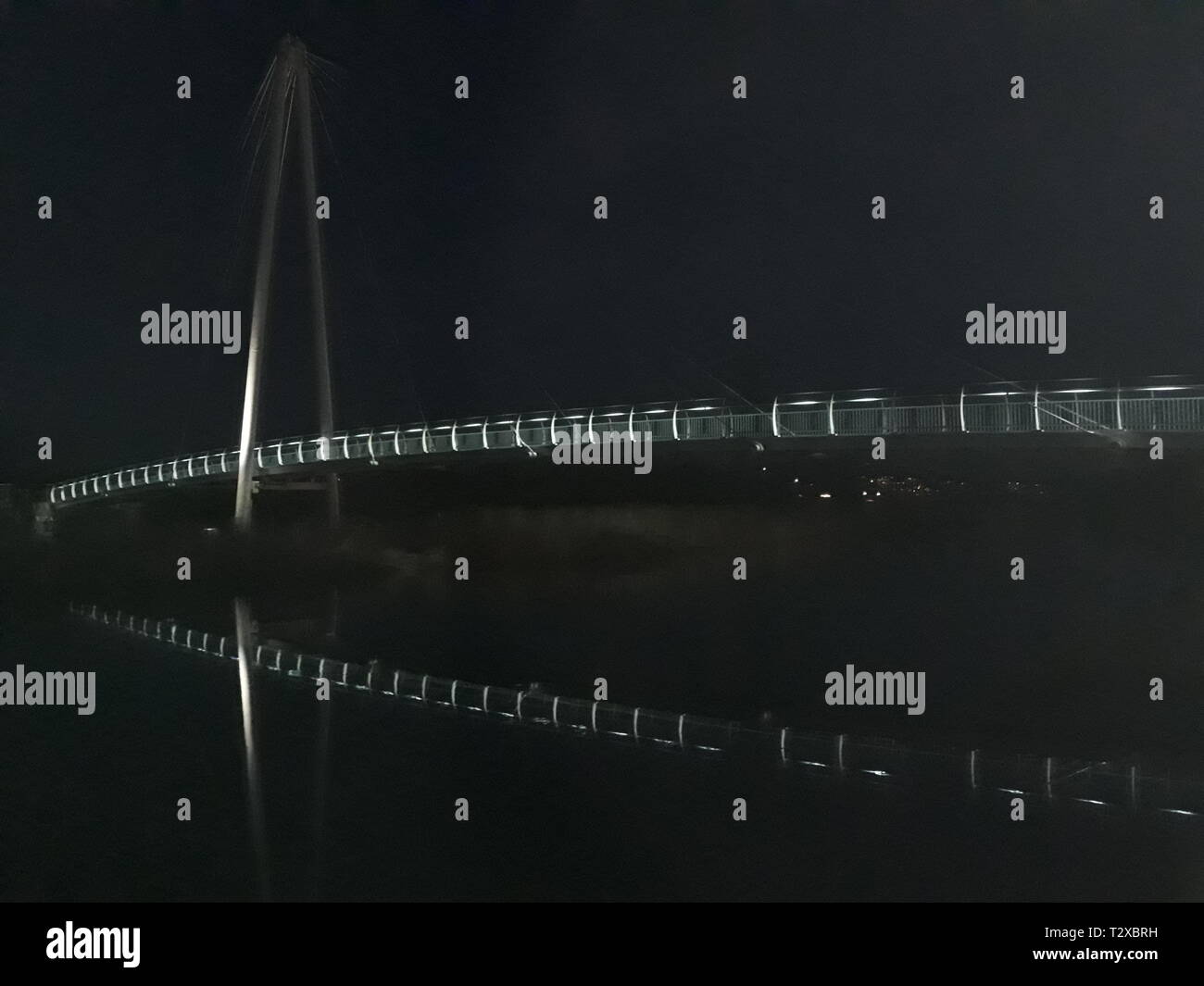 Reflection shot of a modern bridge over the River Lemon at night at