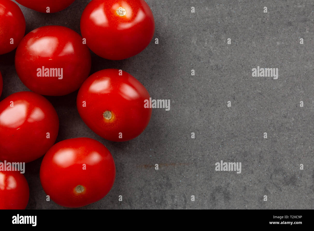 red cherry tomatoes on gray background Stock Photo - Alamy