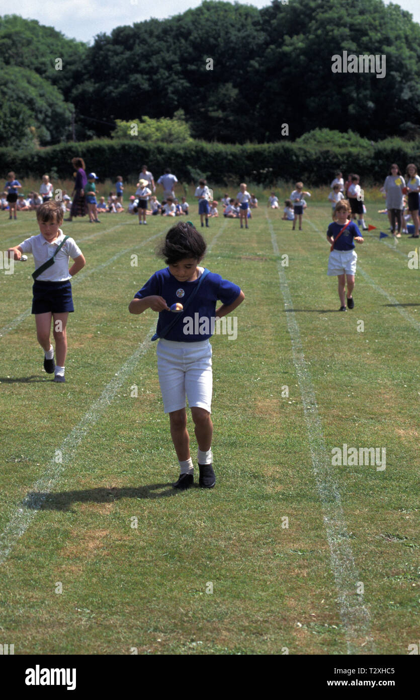 primary school girl in egg and spoon race during sports day Stock Photo